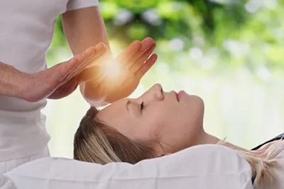 Woman receiving Reiki energy healing therapy