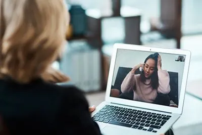 Woman receiving online PTSD therapy with therapist