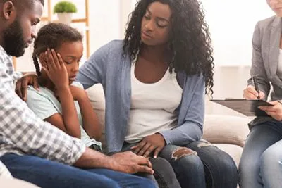 A family participating in a counseling session with a therapist to improve communication, resolve conflicts, and strengthen relationships
