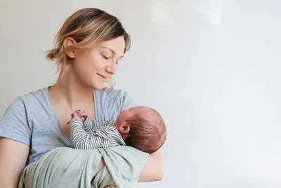 New mom holding newborn, showcasing postnatal care and love