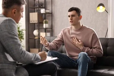 Male patient sharing traumatic experiences with therapist