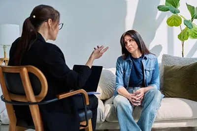 Depressed woman holding a glass of water during depression therapy