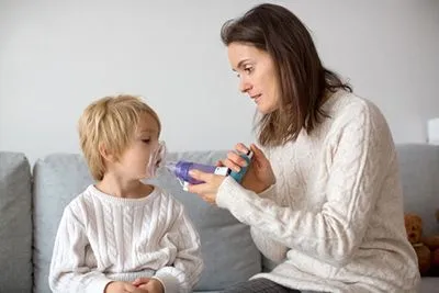 Young boy suffering from Asthma with her mother