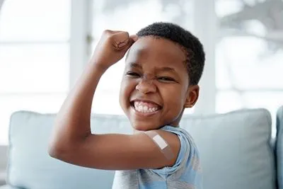Happy child showing vaccinated arm