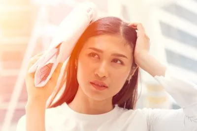 Woman trying to block the ray of the sun on the afternoon