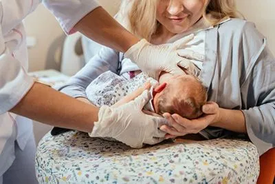 Mother breastfeeding newborn with lactation support