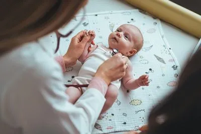 Pediatrician examining newborn baby during checkup
