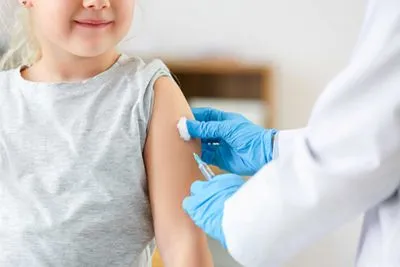 Child getting immunization shot under pediatric care in clinical setting