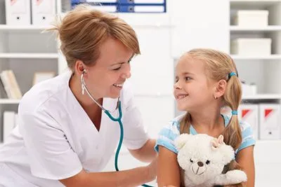 Doctor checking the young girl with smile on her face