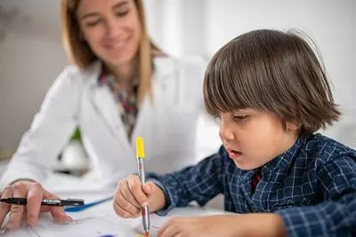 Pediatrician performing developmental screening and cognitive evaluation for child in clinic