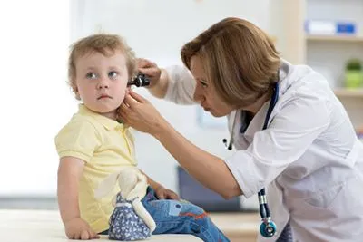 Doctor checking the young boy ear