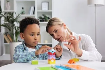 Child solving a puzzle during developmental screening with pediatrician