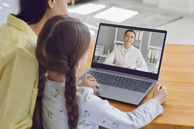 Mom and child during a virtual pediatric consultation with a doctor.