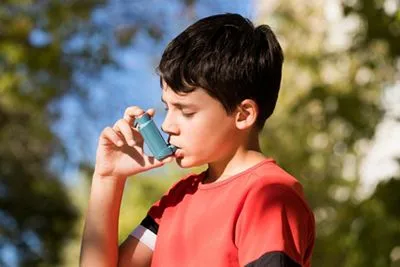 Child managing asthma symptoms with inhaler in an outdoor setting
