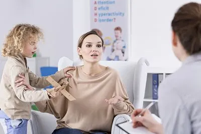 Woman talking to a therapist with annoying boy beside her