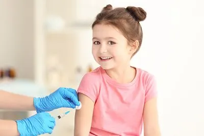 Young girl receiving a vaccine shot in her arm during a routine immunization.