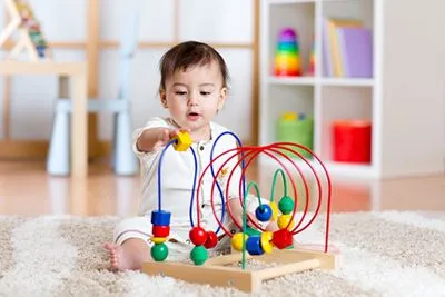 A young boy playing a puzzle on table