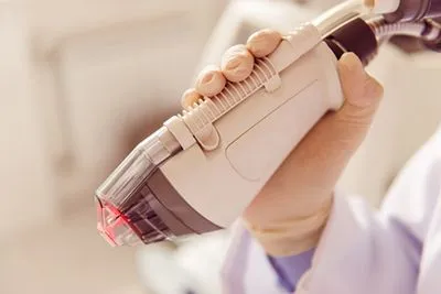Skin specialist preparing a laser device for dermatological treatment