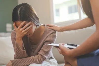 Therapist comforting woman coping with loss during grief therapy
