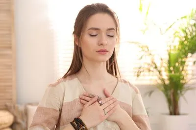 Woman in meditating on home.