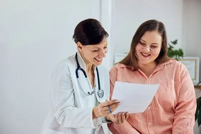 Doctor consulting with overweight female patient about weight management