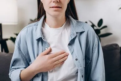 Woman holding her chest in pain