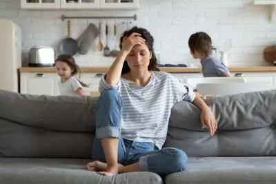 Childrens playing on the background with feeling anoyed mother