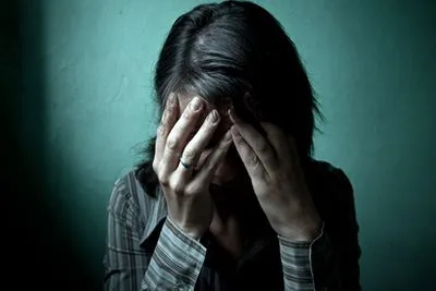 Depressed and anxious woman holding her head.