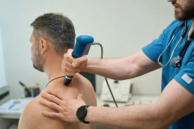 Shockwave treatment session for man with neck pain