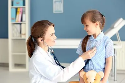 Doctor evaluating child's health during required school physical