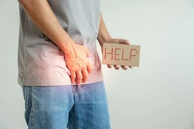 Man holding sign that says 'help' to express struggle with erectile dysfunction