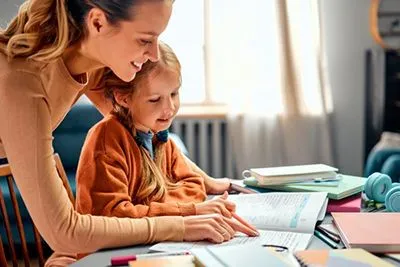 Mother supporting child with visual tracking problem during reading exercise at home