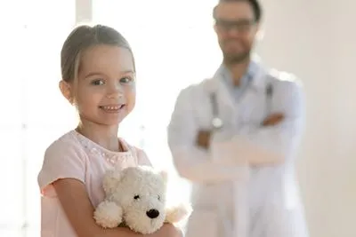 Young girl getting ready for a checkup with pediatrician nearby