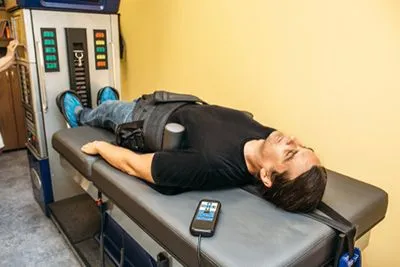 Man undergoing non-surgical spinal decompression on therapy table