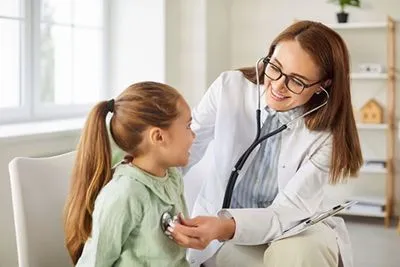 Pediatrician Examining Child During Clinic Visit