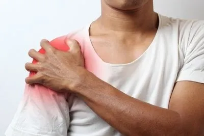 Man holding his shoulder in pain with red highlights