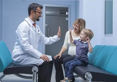 A doctor high fives a child