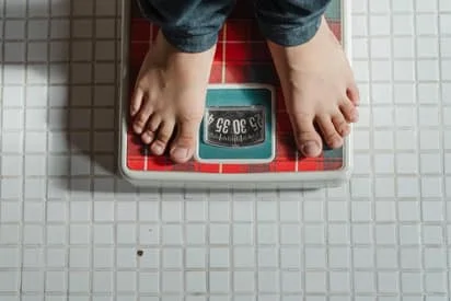 Man on a weighing scale nutritional counseling in Kenosha
