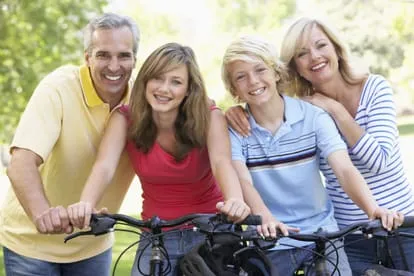 Family smiling and biking