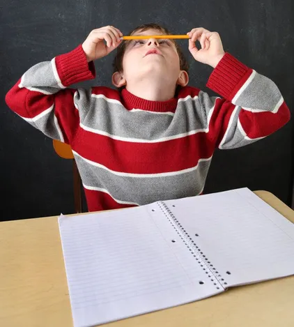 Child balancing pencil on nose