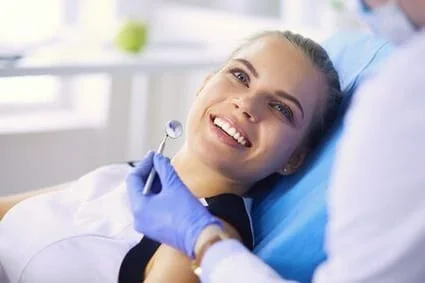 teen girl in dental chair smiling, dental assistant's hand near girl's mouth with dental mirror tool, general dentistry Murrieta, CA