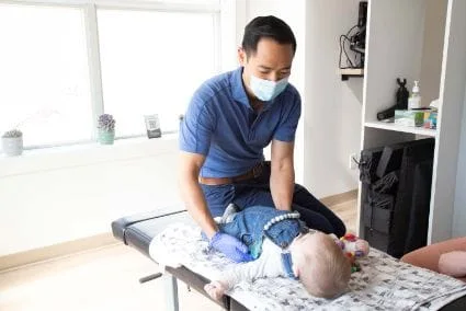 A doctor holding a lying baby