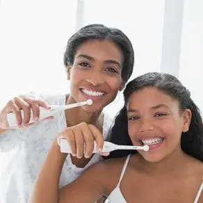 young black girls smiling and brushing teeth with electric toothbrushes, dental hygienist Hilo, HI family dentistry