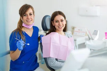 dental hygienist examining female patient in dental exam chair, general dentistry Mt Airy, NC dentist