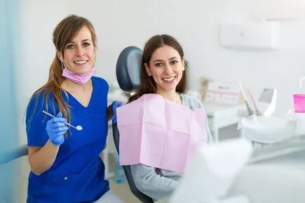 dental hygienist with female patient in dental exam room, teeth cleaning Financial District, NY dentist 