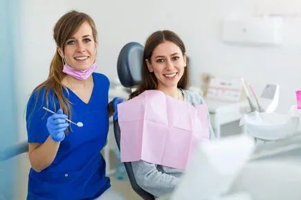 dental hygienist next to female patient getting dental exam and teeth cleaning Naperville, IL dentist