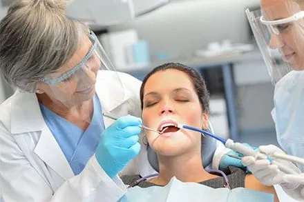 female dentist and staff performing emergency dental work on female patient, Emergency Dentist Lake Worth, FL