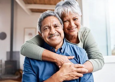 older couple smiling and embracing, nice teeth with removable dentures Lubbock, TX dentist