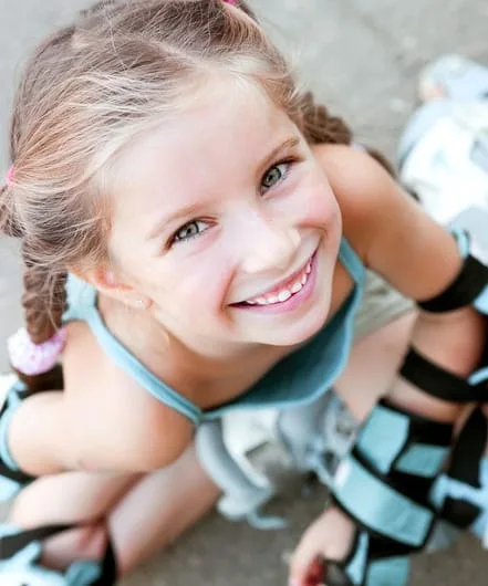 Smiling young girl with rollerblades on