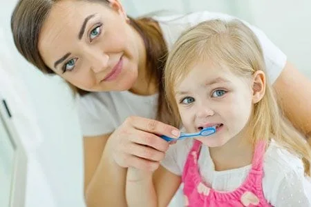Mom and Daughter brushing their teeth - Dentist in Huntsville, AL